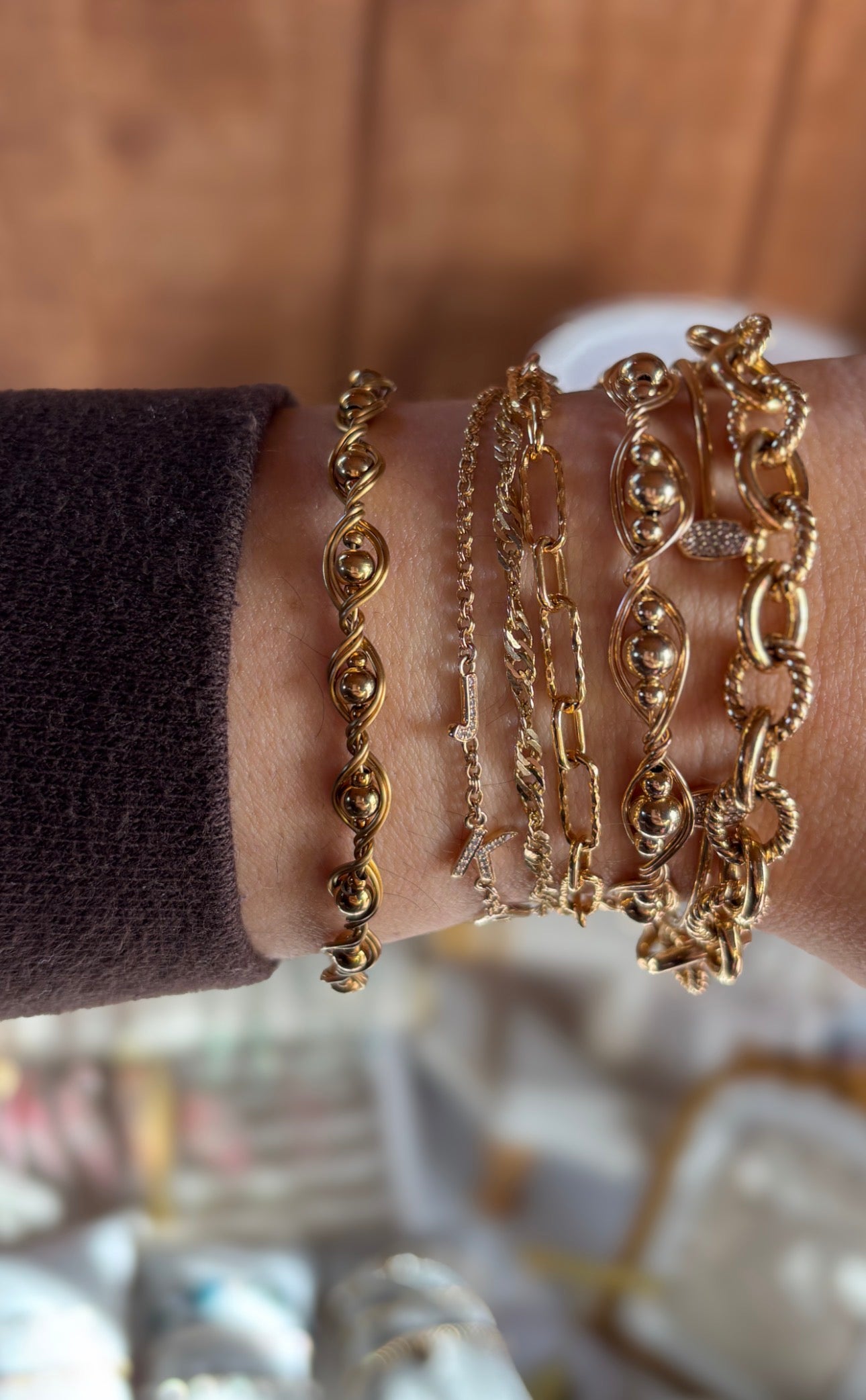 Gold bracelets on a wrist with a blurred background