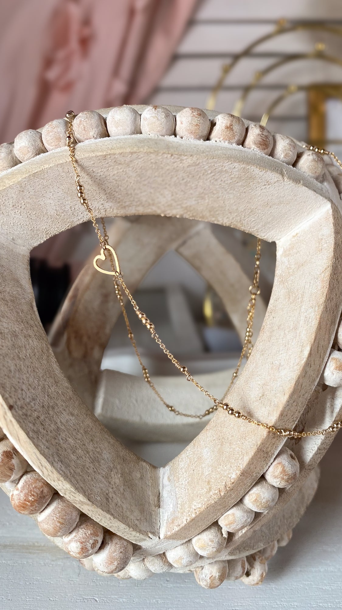Heart-shaped necklace with decorative beads on a light background