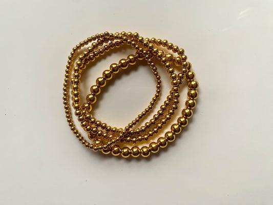 Stainless steel gold beaded bracelet stack.