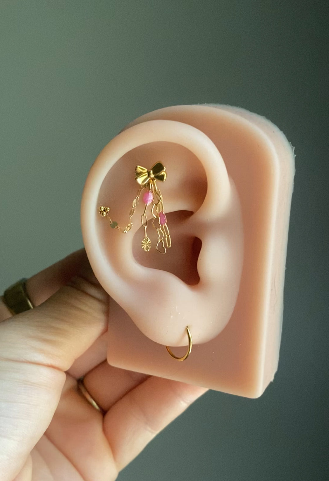 Handmade 14kt gold filled ear chain charm featuring a dainty heart dangle, pink glitter enamel starburst chain, and dapped leaf chain accents.
