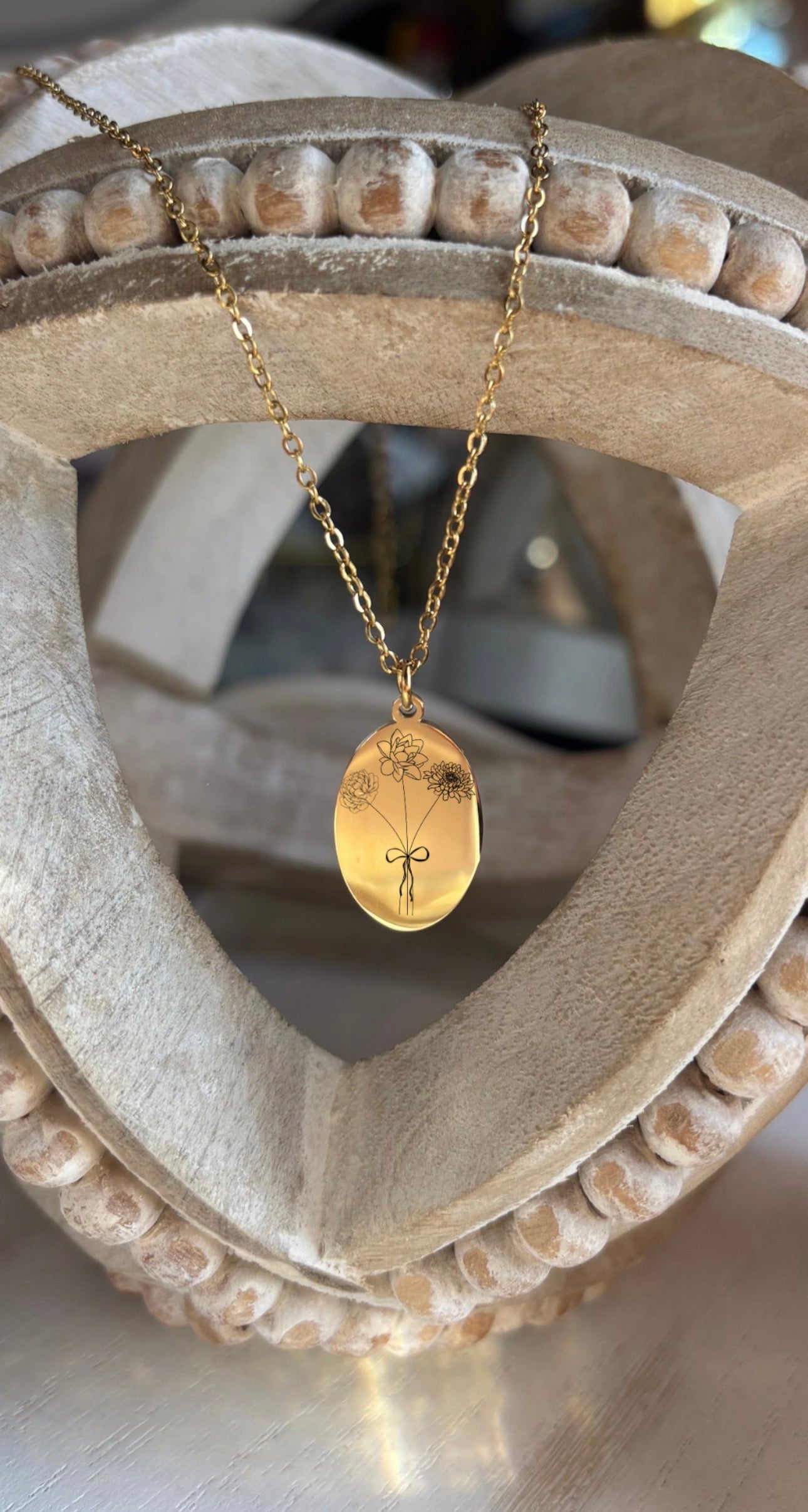 Gold necklace with a pendant on a decorative wooden stand