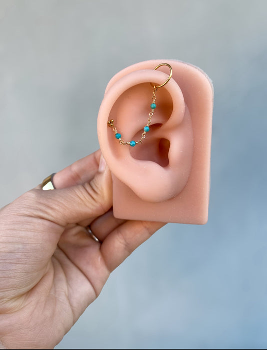 This chain is made with 14kt gold filled chain, and 2mm natural turquoise. 

SOLD AS A SINGLE 

Measures about 39mm not including jumprings ! 

Chains/Charms are the perfect way to add a little extra sparkle to your existing jewelry. ✨ They can be worn on post up to 16g. Just be sure your post has enough length to fit the extra detail. Easy to wear, effortless to style, and totally you.

SOLD AS A SINGLE - CHAINS ONLY - Earring and Earring post sold separately. Earring in video and pictures are for display 