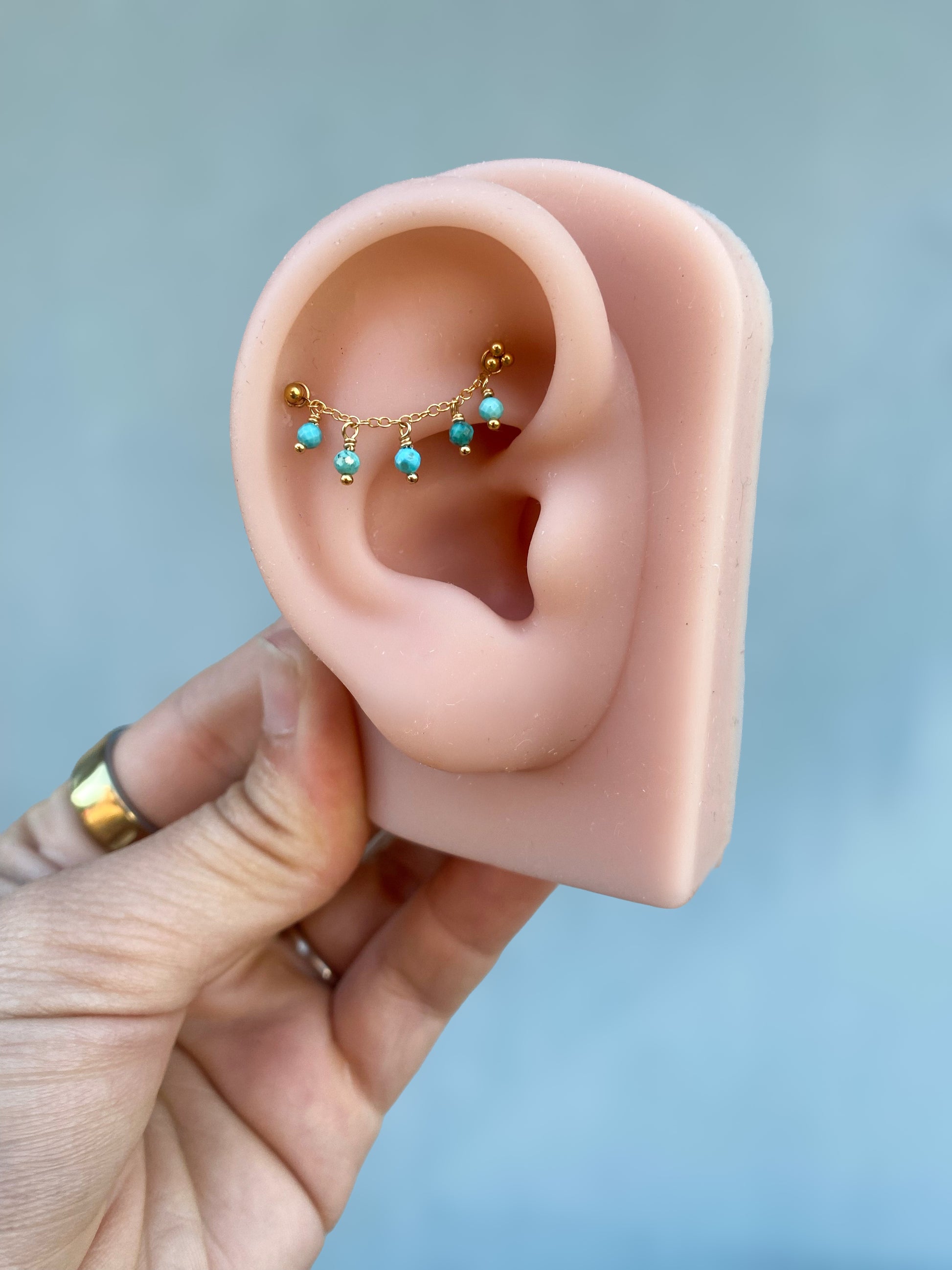 This chain is made with 14kt gold filled chain, and 2mm natural turquoise. 

SOLD AS A SINGLE 

Measures about 25mm not including jumprings ! 

Chains/Charms are the perfect way to add a little extra sparkle to your existing jewelry. ✨ They can be worn on post up to 16g. Just be sure your post has enough length to fit the extra detail. Easy to wear, effortless to style, and totally you.

SOLD AS A SINGLE - CHAINS ONLY - Earring and Earring post sold separately. Earring in video and pictures are for display 