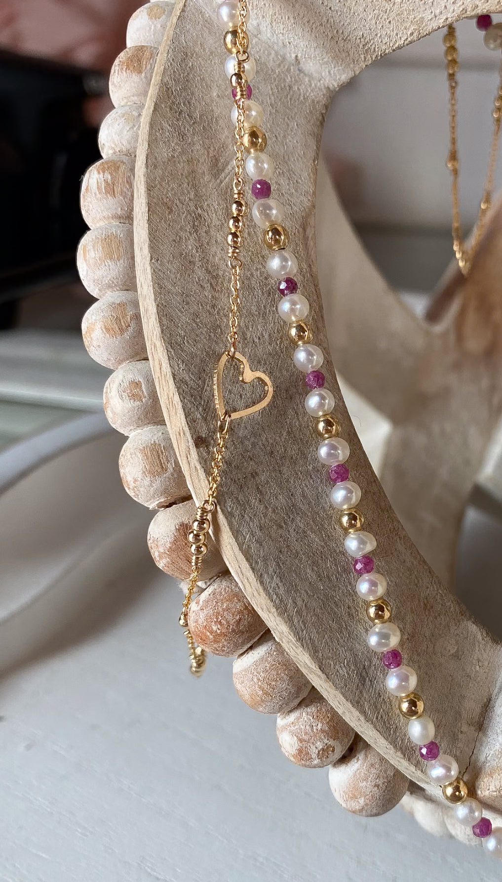 Necklace with heart pendant and beads on a decorative stone surface