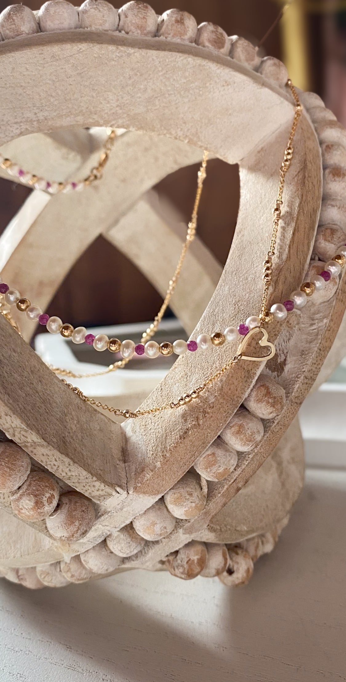 Necklace with heart pendant draped over a decorative stone object