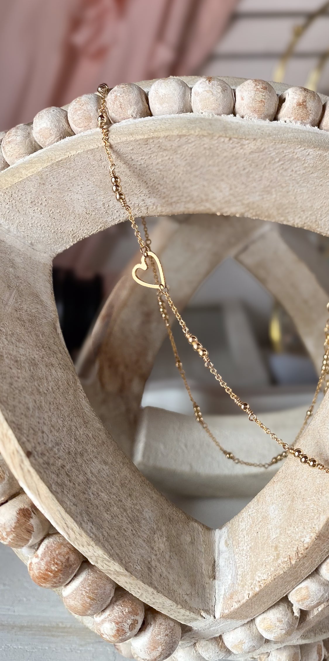 Gold necklace with a heart pendant on a stone surface