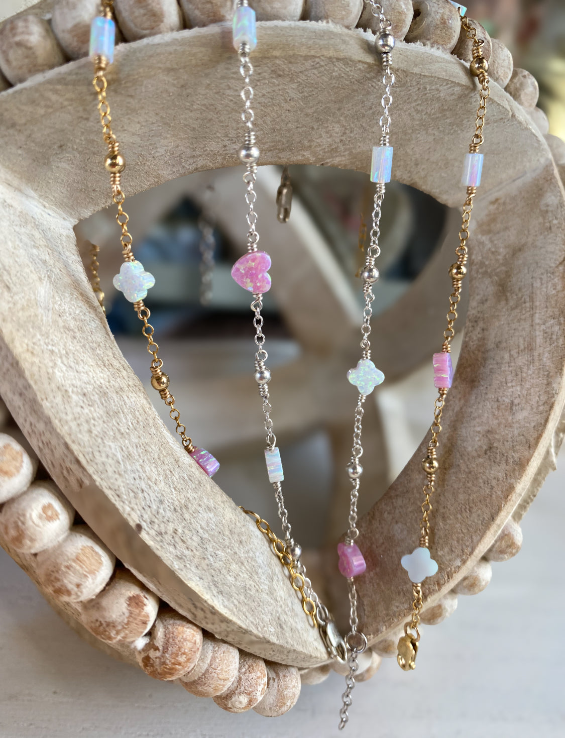 Handmade opal charm chain bracelet with iridescent gemstones, shown stacked on display for styling inspiration, available in gold filled and sterling silver