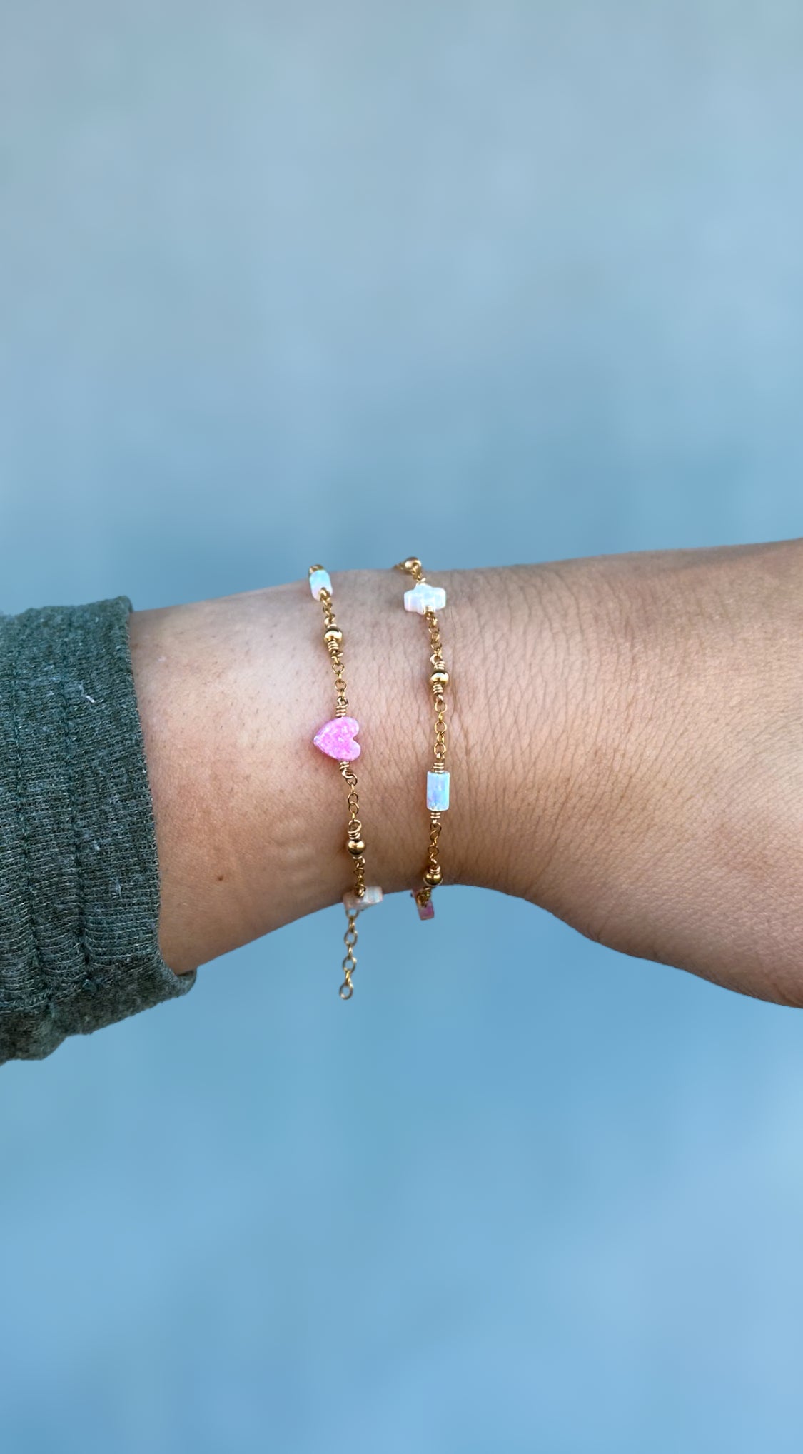Handmade opal charm chain bracelet with iridescent gemstones, shown stacked on wrist for styling inspiration, available in gold filled and sterling silver