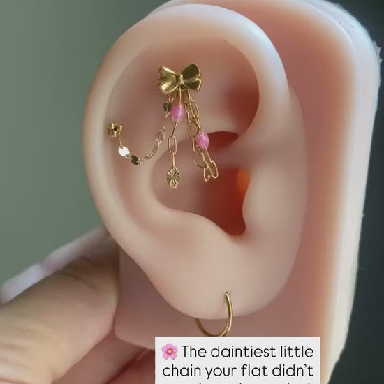 Handmade 14kt gold filled ear chain charm featuring a dainty heart dangle, pink glitter enamel starburst chain, and dapped leaf chain accents.
